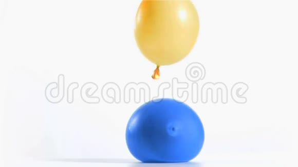 黄色气球在蓝色气球上以超慢动作反弹视频的预览图
