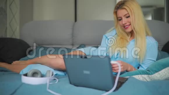 在家里用笔记本电脑的女人躺在床上视频的预览图