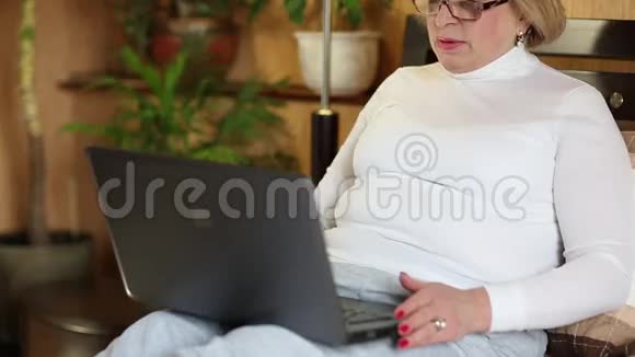 高级女性使用笔记本电脑进行交流带手提电脑的女人视频的预览图