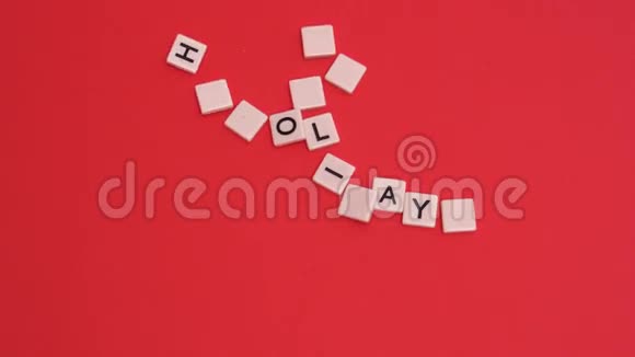 字母瓷砖移动在红色背景上拼出快乐的节日视频的预览图