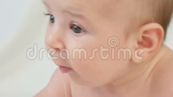 躺在白床上的两个月小婴儿的美丽滑稽肖像视频的预览图