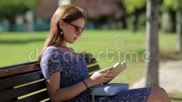 年轻女子看书坐在长凳上视频的预览图