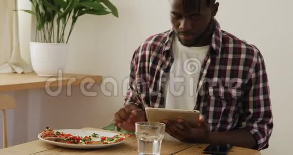 男人在家吃饭用平板电脑视频的预览图
