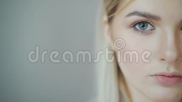 美女金发在镜头里看特写女孩打开了照相机的眼睛视频的预览图