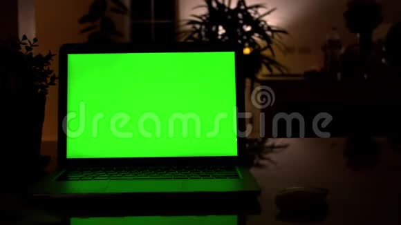 在客厅的办公桌上展示绿色彩色钥匙屏幕的笔记本电脑在后台舒适的客厅里视频的预览图