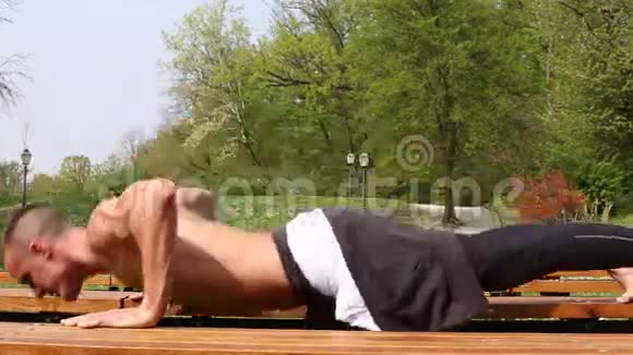 特写肌肉男在长凳上做俯卧撑视频的预览图