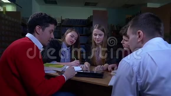 一群学生坐在图书馆的桌子旁视频的预览图