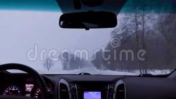 在暴风雪中驾驶一辆车在冬天的乡间小路上视频的预览图