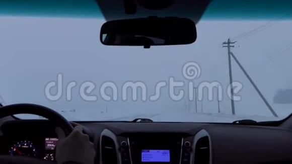 在暴风雪中驾驶一辆车在冬天的乡间小路上视频的预览图