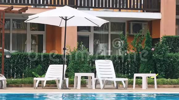 室外游泳池周围有漂亮的豪华雨伞和椅子视频的预览图