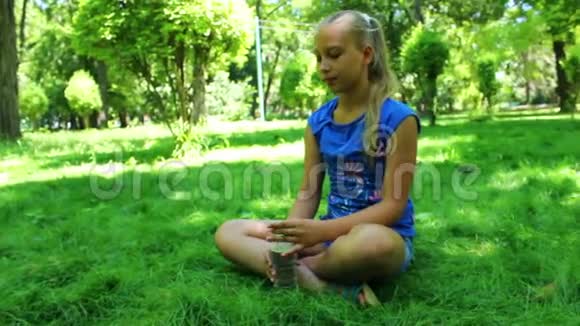 在公园里喝水的年轻少女视频的预览图