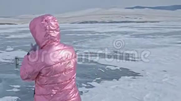 女孩走在冰封的贝加尔湖上女旅行者探索和看一个浮冰它很神奇视频的预览图