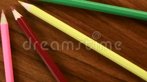 许多五颜六色的铅笔在黑色的木制背景上以一个圆圈旋转概念办公室或学校知识日第一次视频的预览图
