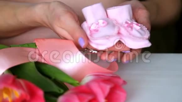 怀孕的夫妇手里拿着粉红色的小袜子孕妇视频的预览图