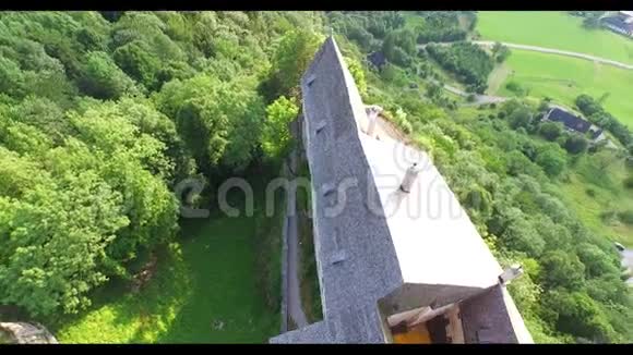 山顶城堡的鸟瞰图周围是森林后面是奥地利阿尔卑斯山的一部分视频的预览图
