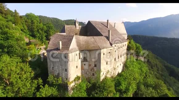 山顶城堡的鸟瞰图和周围的森林以及奥地利阿尔卑斯山的一部分景观视频的预览图
