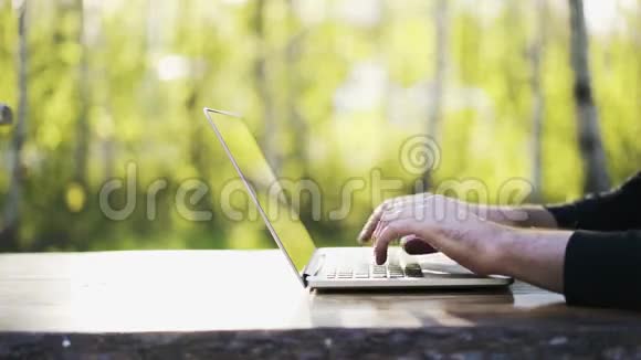 一个人在公园里用手提电脑键盘打字视频的预览图