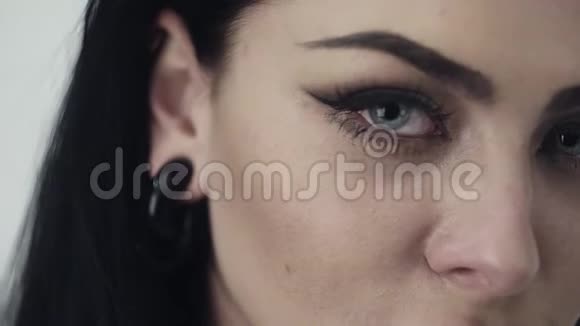 嘴唇可爱的女孩的脸蓝色的大眼睛黑色的长发和化妆视频的预览图