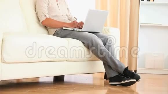 坐在沙发上搜索网络的人视频的预览图