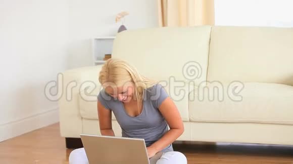女人坐在地上腿上放着笔记本视频的预览图