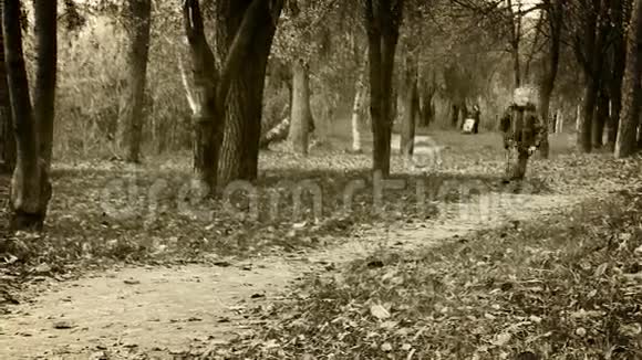 独自一个小男孩快乐地在秋天公园散步视频的预览图
