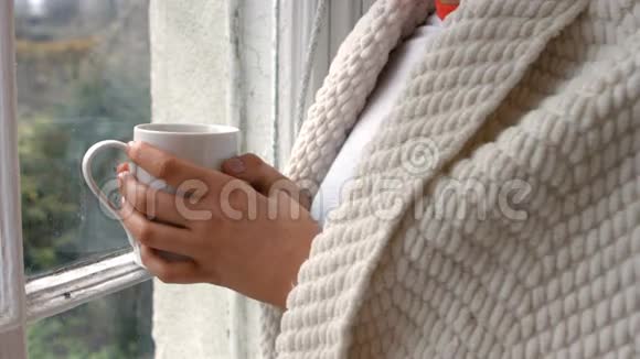 站在窗边喝咖啡的女人视频的预览图