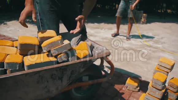 施工现场施工工人从手推车上卸下石材铺贴慢动作视频的预览图