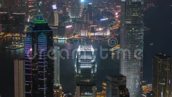 香港城市的天际线在夜晚随着维多利亚港和摩天大楼在水中的灯光照亮视频的预览图