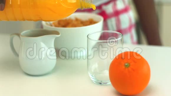 早餐时将橙汁倒入玻璃杯中视频的预览图