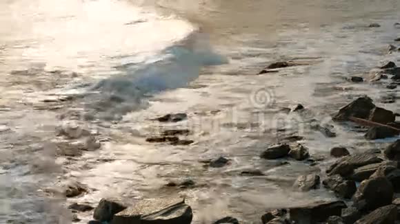 海水在日落时轻轻地冲刷岩石慢慢视频的预览图