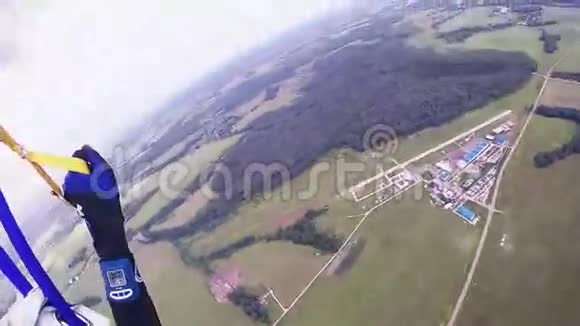 专业跳伞员乘降落伞飞越绿野森林极限运动视频的预览图