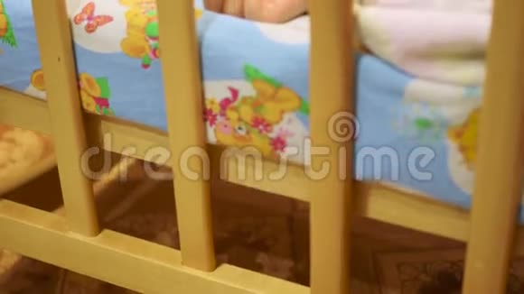 可爱的宝宝和一只玩具熊睡在小床上视频的预览图