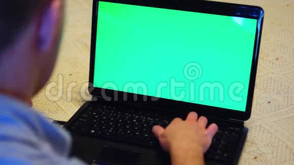 男人用绿色屏幕看笔记本电脑视频的预览图