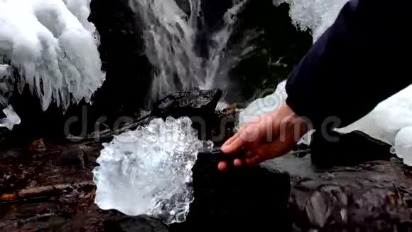 手与强烈的闪光灯闪耀成美丽的大冰与抽象的裂缝跌入冰柱贝娄瀑布视频的预览图