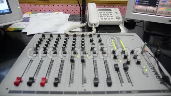 电台专业的多机架混合控制台控制室内的电脑和麦克风录音和广播专业人员视频的预览图