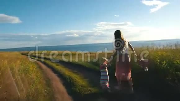 美丽的年轻家庭在河的背景和阳光下沿着悬崖奔跑视频的预览图