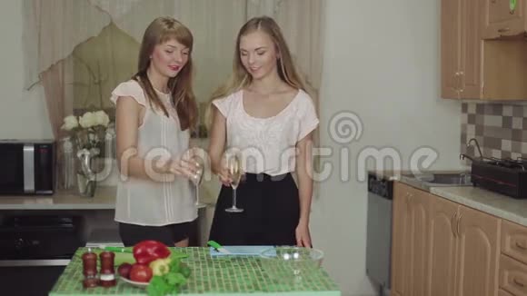 女人在厨房里做饭一边说着喝着香槟微笑着快速地吃着健康的食物视频的预览图