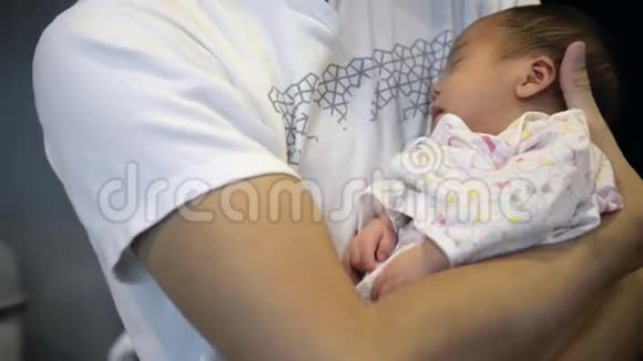 新生儿在父亲怀抱中的女性特写视频的预览图