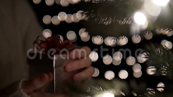 女士打开圣诞礼品盒背景灯视频的预览图
