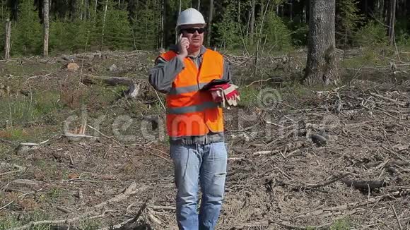 森林工程师在被摧毁的森林里用手机聊天视频的预览图