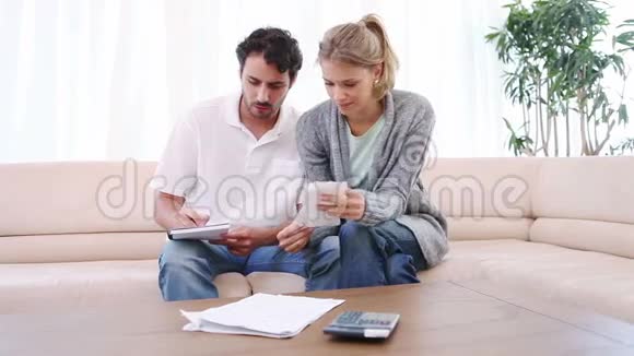微笑的夫妇检查他们的账单视频的预览图
