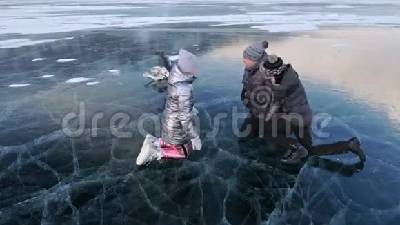 一家人在美丽的冰面上玩得很开心父亲母亲儿子和女儿在冰上嬉戏做三明治做三明治视频的预览图