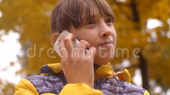 女孩在秋天公园打电话微笑着视频的预览图