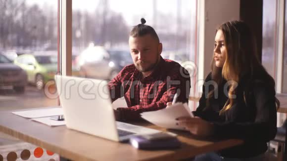 年轻的自由职业者坐在咖啡馆里为笔记本电脑工作视频的预览图