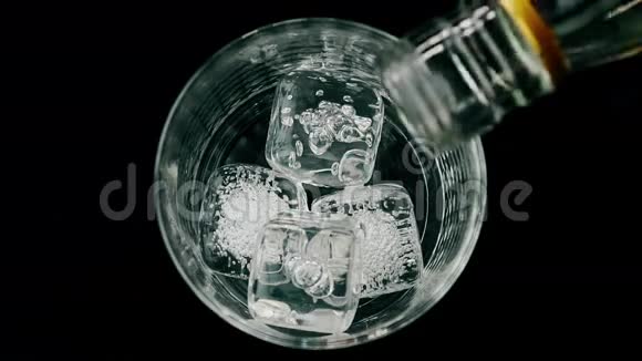 酒吧服务员在木桌上的玻璃上倒入装有冰块的威士忌观看顶部放松时间视频的预览图