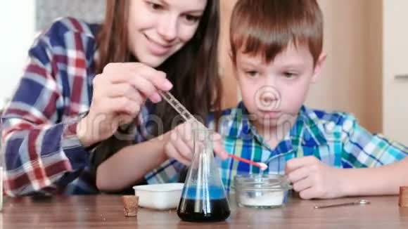 在家里做化学实验妈妈和儿子在烧瓶里释放气体后发生化学反应视频的预览图