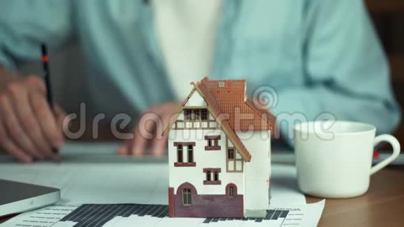 年轻建筑师创造住房项目桌上的房子模型视频的预览图