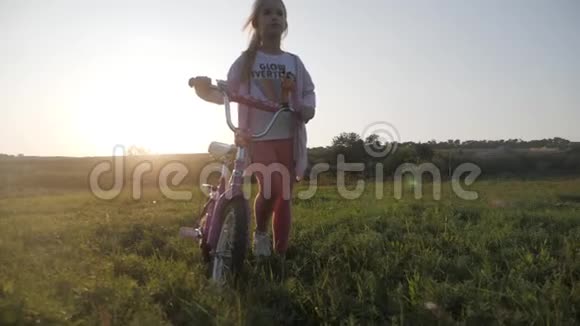 骑自行车的孩子在日落时骑自行车享受自由日落时骑自行车在乡下的女孩视频的预览图