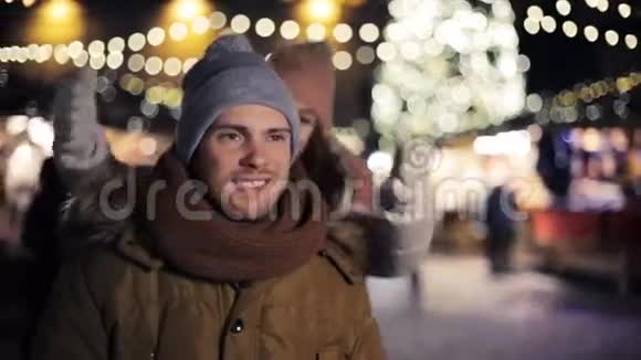 快乐的一对夫妇在圣诞市场上玩得开心视频的预览图