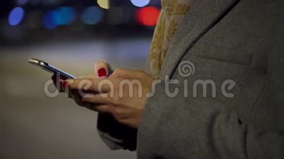 女性手使用智能手机模糊城市灯光背景视频的预览图